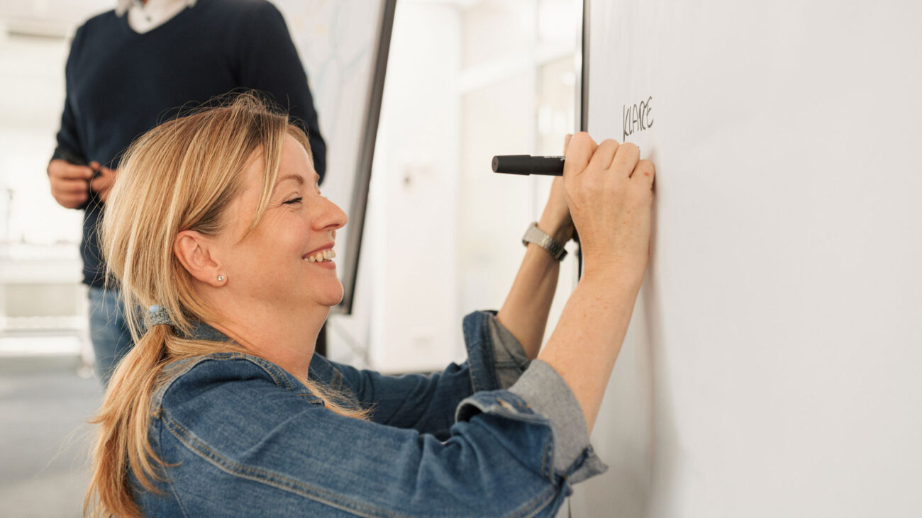 Trainerin für Stressmanagement schreibt auf Whiteboard